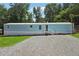Charming light blue single-story home with a white foundation, gravel driveway, and small porch entrance at 4820 Scott Rd, Cumming, GA 30041