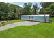 Spacious front yard and gravel driveway lead up to this light blue single-story home with white foundation at 4820 Scott Rd, Cumming, GA 30041