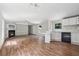 Open-concept living space with modern hardwood floors, fireplace, and access to the adjacent kitchen at 4820 Scott Rd, Cumming, GA 30041