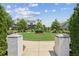 Scenic view of community green with brick entrance, mature trees, and well-maintained landscaping at 6930 Whitman Walk, Alpharetta, GA 30005