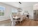 Dining room with a wooden table and upholstered chairs beneath a modern light fixture at 6930 Whitman Walk, Alpharetta, GA 30005