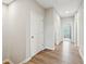 A hallway with hardwood floors and neutral paint, offering access to rooms with natural light at 6930 Whitman Walk, Alpharetta, GA 30005