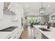 Gourmet kitchen overlooking the living room boasts white cabinets, stainless steel appliances, and a center island at 6930 Whitman Walk, Alpharetta, GA 30005