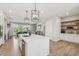 Bright, open kitchen with an island, stainless steel appliances, and wooden floors leading to the living room at 6930 Whitman Walk, Alpharetta, GA 30005