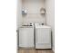 Convenient laundry area with modern washer and dryer, plus shelving for storage at 6930 Whitman Walk, Alpharetta, GA 30005