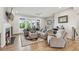 Open living room features hardwood floors, a fireplace, neutral decor, and large windows providing natural light at 6930 Whitman Walk, Alpharetta, GA 30005