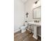 Tastefully appointed powder room with pedestal sink, decorative fixtures and attractive flooring at 6930 Whitman Walk, Alpharetta, GA 30005