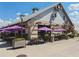 Outdoor dining at the Cattle Shed, featuring modern decor and purple umbrellas at 6930 Whitman Walk, Alpharetta, GA 30005