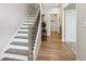 View of a staircase with stained wood handrail and white risers, leading to the upper level of the home at 6930 Whitman Walk, Alpharetta, GA 30005