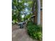 Side exterior of house with a long driveway, lush foliage, and mature trees providing shade at 1383 Natchez Sw Trce, Marietta, GA 30008