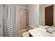 Bathroom with shower featuring a patterned curtain, a white sink, and a standard toilet at 4800 Timber Ridge Dr, Douglasville, GA 30135