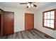 Cozy bedroom features a ceiling fan, hardwood floors, and a window with natural light at 4800 Timber Ridge Dr, Douglasville, GA 30135