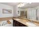 Elegant bathroom featuring a soaking tub, double vanity with granite counters, and a separate glass-enclosed shower at 6038 Mayfield Se Way, Mableton, GA 30126