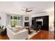 Stylish living room with fireplace, built-in shelving, and large window overlooking the backyard at 6038 Mayfield Se Way, Mableton, GA 30126