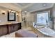 Bathroom with a soaking tub under a decorative window, plus a glass enclosed shower at 10020 Normandy Ln, Suwanee, GA 30024