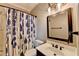 Bathroom features a vanity, mirror, shower, and decorative shower curtain at 10020 Normandy Ln, Suwanee, GA 30024