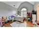 Bright bedroom with hardwood floors, decorative rug, and arched window at 10020 Normandy Ln, Suwanee, GA 30024
