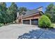 Brick home featuring a two-car garage, concrete driveway, and professional landscaping at 10020 Normandy Ln, Suwanee, GA 30024