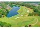 Aerial view of a lush golf course with a picturesque lake, sand traps, and manicured greens at 10020 Normandy Ln, Suwanee, GA 30024