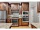Custom kitchen features stainless steel appliances, granite countertops, and wood cabinets at 10020 Normandy Ln, Suwanee, GA 30024
