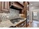 Kitchen with stainless steel cooktop, granite countertops, and mosaic tile backsplash at 10020 Normandy Ln, Suwanee, GA 30024