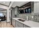 Contemporary kitchenette features stainless appliances, stone backsplash and seamless connection to the theater room at 10020 Normandy Ln, Suwanee, GA 30024