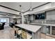 Stylish kitchenette with a gray island and seating that connects to a home theater space at 10020 Normandy Ln, Suwanee, GA 30024