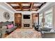 A beautiful living room features a stone fireplace, coffered ceilings, and lovely furnishings at 10020 Normandy Ln, Suwanee, GA 30024