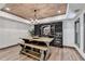 Beautiful wine cellar features a wood ceiling, custom racks and a large tasting table at 10020 Normandy Ln, Suwanee, GA 30024
