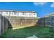 Backyard with grass and wooden fence and view of back of townhomes at 160 Auburn Gate Ln, Auburn, GA 30011
