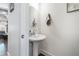 Powder room with pedestal sink and decorative mirror and dark wood floors at 160 Auburn Gate Ln, Auburn, GA 30011