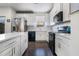 A modern kitchen featuring white cabinets, stainless steel appliances, and a dark hardwood floor at 160 Auburn Gate Ln, Auburn, GA 30011