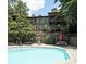 Community pool with building in background, surrounded by lush greenery; the perfect spot for relaxation at 3907 Cedar Cir, Tucker, GA 30084