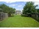 Large, level backyard with a well-maintained lawn and a classic wooden fence, offering privacy and space for recreation at 5010 Amber Leaf Dr, Roswell, GA 30076