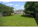 Expansive backyard featuring a lush lawn, mature trees, and a charming patio area perfect for outdoor relaxation and entertaining at 5010 Amber Leaf Dr, Roswell, GA 30076