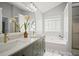 Bright bathroom featuring double sinks, white marble floors, and a separate tub and shower at 5010 Amber Leaf Dr, Roswell, GA 30076