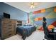 A colorful bedroom with a large dresser, tv, and a comfortable bed at 5010 Amber Leaf Dr, Roswell, GA 30076