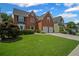 Charming two-story brick home with well-kept lawn and two-car garage at 5010 Amber Leaf Dr, Roswell, GA 30076