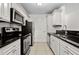 Updated kitchen with white cabinets, black countertops and stainless steel appliances at 5207 Santa Fe Pkwy, Sandy Springs, GA 30350