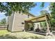 Rear view of home with covered patio, grill, four chairs, and well-maintained lawn at 5696 Walnut Mill Ln, Powder Springs, GA 30127