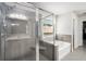 Bathroom with tile walls, glass shower, soaking tub, tiled floors, and natural light at 5696 Walnut Mill Ln, Powder Springs, GA 30127
