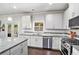 Well-lit kitchen with white cabinets, stainless steel appliances and granite countertops at 5696 Walnut Mill Ln, Powder Springs, GA 30127