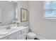 Clean bathroom with white cabinets, sink, toilet, and window at 6179 Ashbranch Dr, Acworth, GA 30101