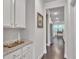 Hallway features granite counters, white cabinets, and view into kitchen at 6179 Ashbranch Dr, Acworth, GA 30101