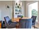 Cozy dining nook with a round table, blue chairs, built-in shelving, and a large window overlooking the green trees at 1 Biscayne Drive Nw # 706, Atlanta, GA 30309