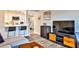 Open-concept living space featuring a kitchen with white cabinets, bar seating and media center with flatscreen TV at 1 Biscayne Drive Nw # 706, Atlanta, GA 30309