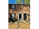 Brick townhouse exterior featuring black shutters, open front door, and patio area at 106 Plantation Dr, Clarkston, GA 30021