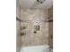 Shower featuring cream-colored tiles, a niche, and black metal fixtures at 106 Plantation Dr, Clarkston, GA 30021