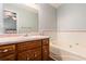 Bathroom features a vanity with a sink, a large mirror, and a tub at 487 Laney Rd, Locust Grove, GA 30248