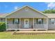 Inviting front porch with rocking chairs, leading to the entrance of a charming single-story home at 487 Laney Rd, Locust Grove, GA 30248